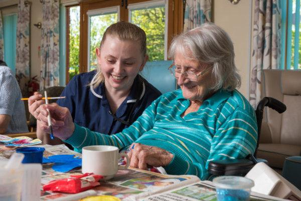 Care worker taking part in an activity with an older person